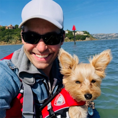 Peer Support Volunteer Eric Lindroos and Dog in life vests on the water